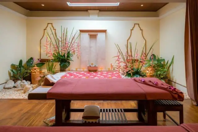 Hergerichteter Behandlungsraum eines Massagestudios mit Blütendekoration