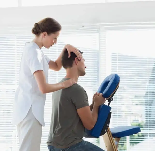 Nacken- und Schulterbehandlung am Massagestuhl in einer hellen Praxis
