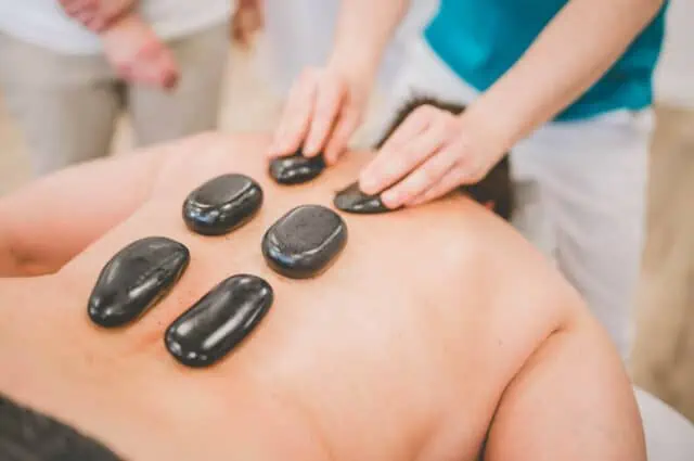 Warme Hot-Stone-Steine werden auf dem Rücken platziert